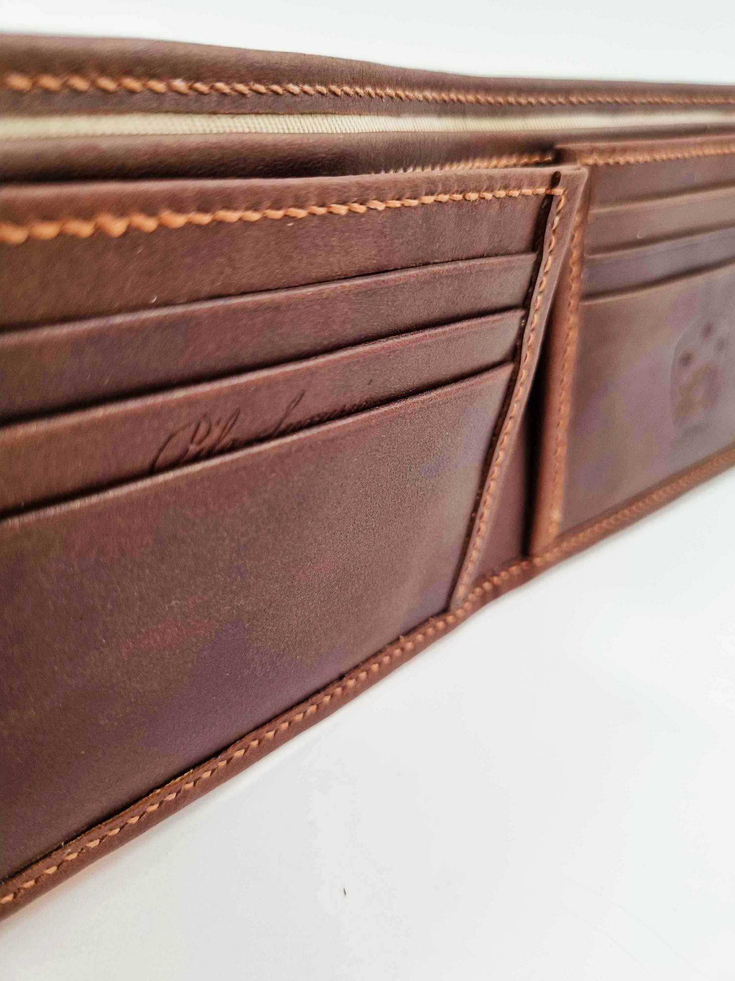 Brown leather wallet with Pila Luxuria script logo up close