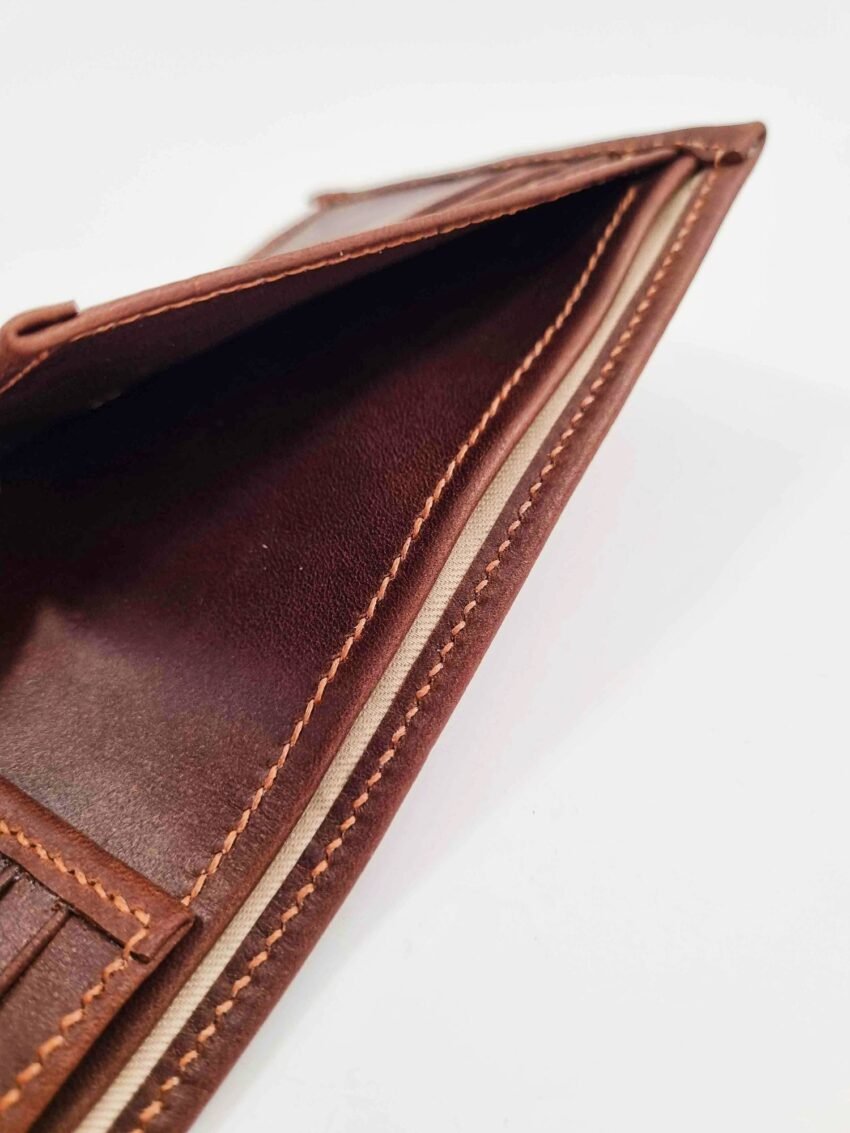 Brown leather wallet with cloth lined pocket and hand stitching.