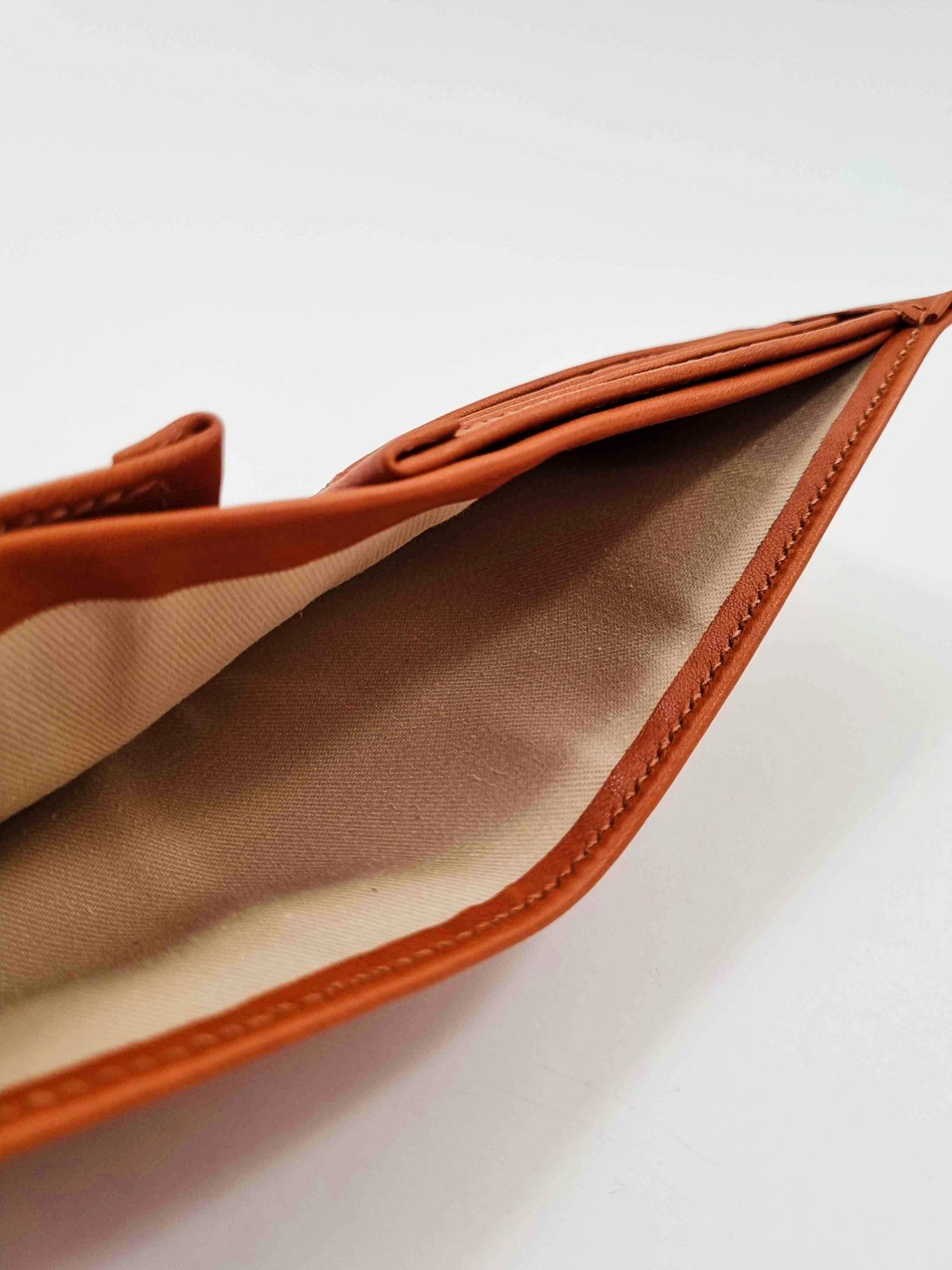 Brown leather wallet open showing cloth cash pocket