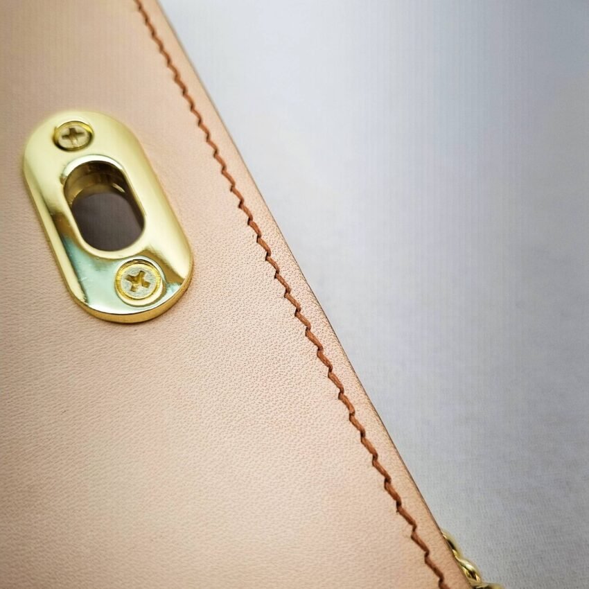 A biscuit colored epsom leather purse made by Pila Luxuria in Alberta, Canada showing detailed stitching.