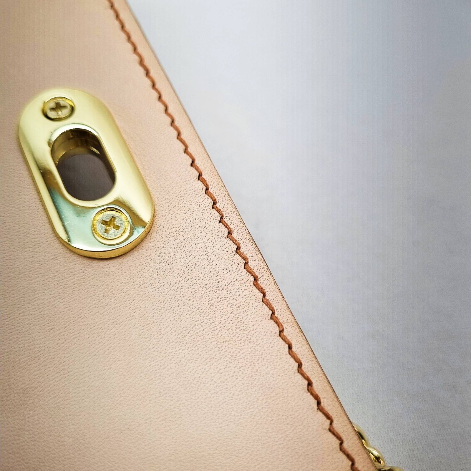 A biscuit colored epsom leather purse made by Pila Luxuria in Alberta, Canada showing detailed stitching.