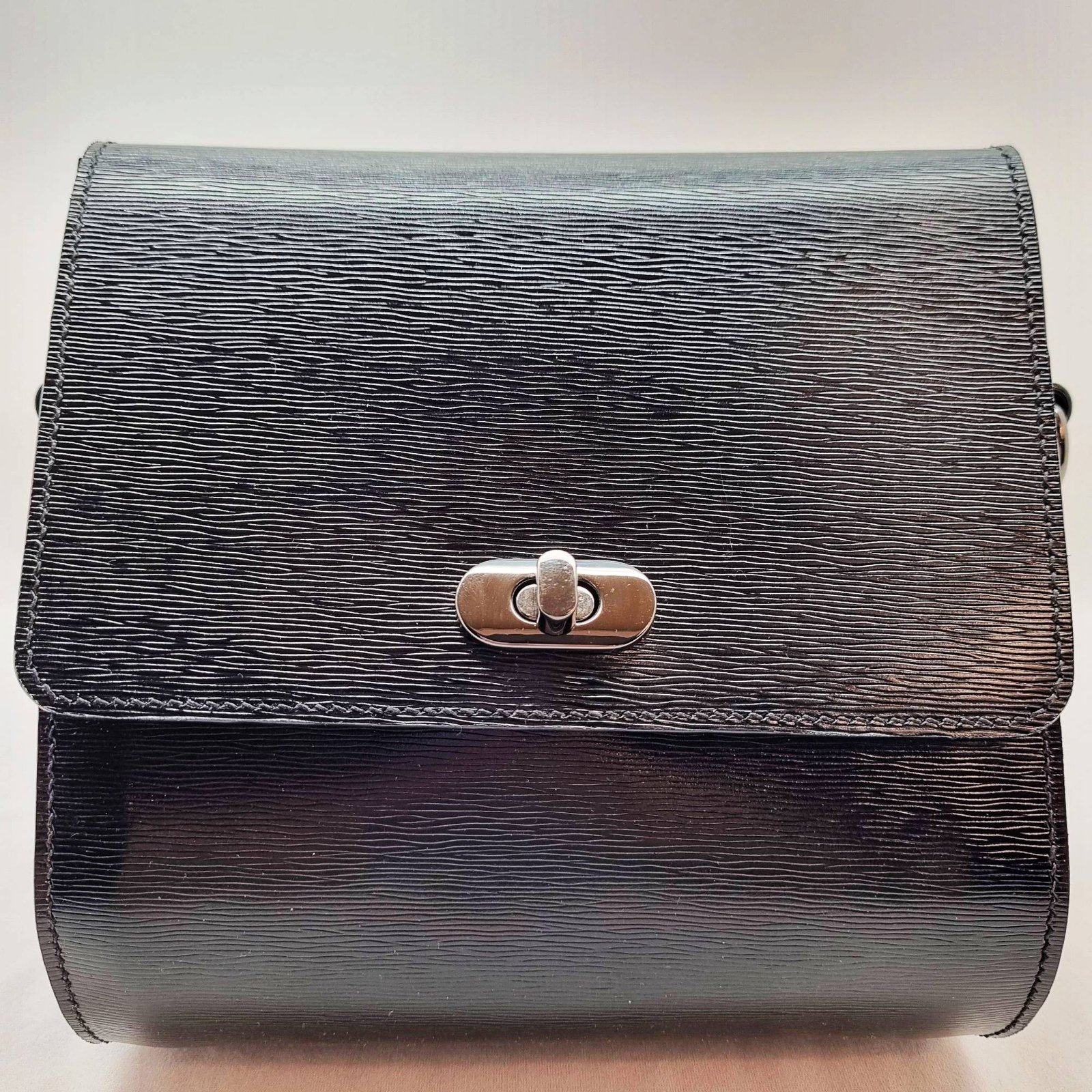 A black epi leather purse made by Pila Luxuria in Alberta, Canada displayed from the front.
