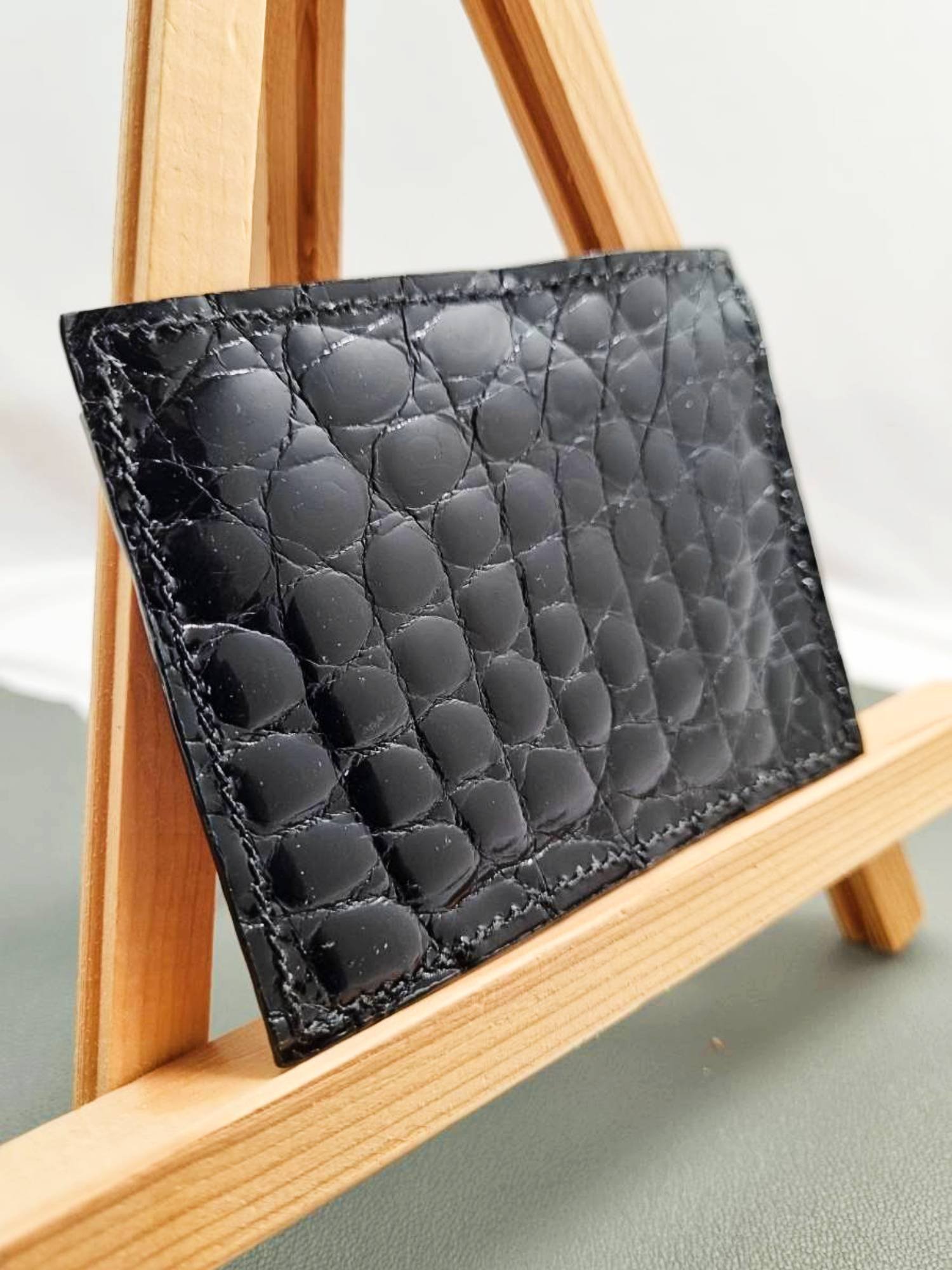 Black mirror finish crocodile leather card holder made by Pila Luxuria in Canada shown from the back.