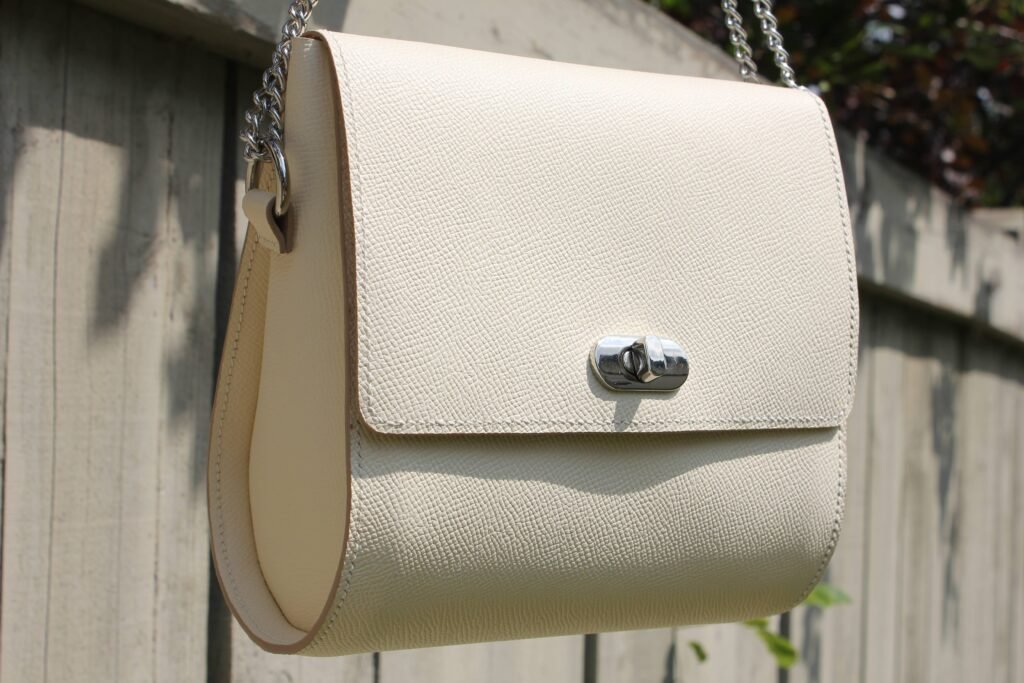 Angled view of a luxury craie epsom chestnut leather purse with a silver clasp, made by Pila Luxuria in Canada.
