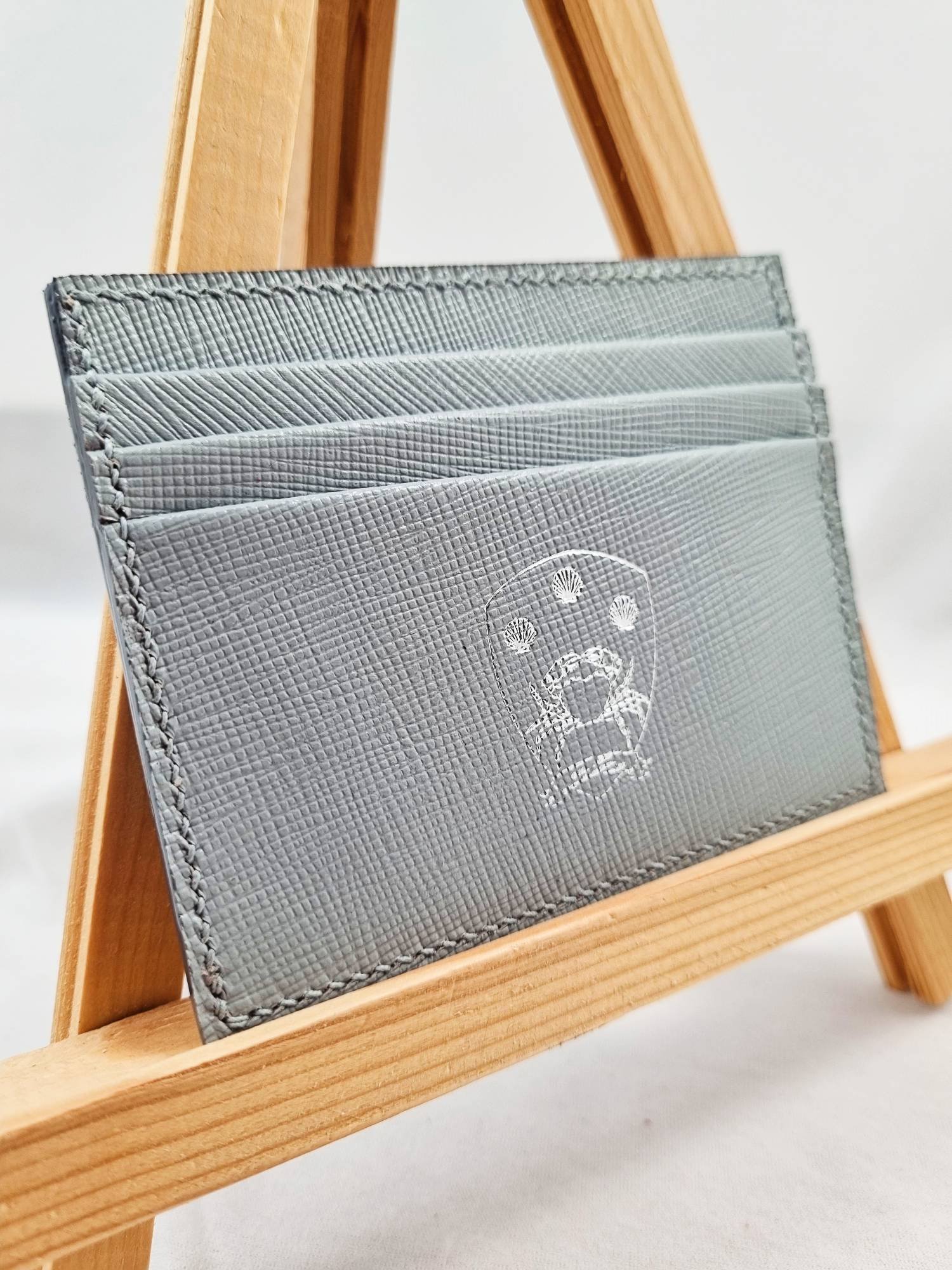 Grey saffiano calfskin wallet with Pila Luxuria logo at angle