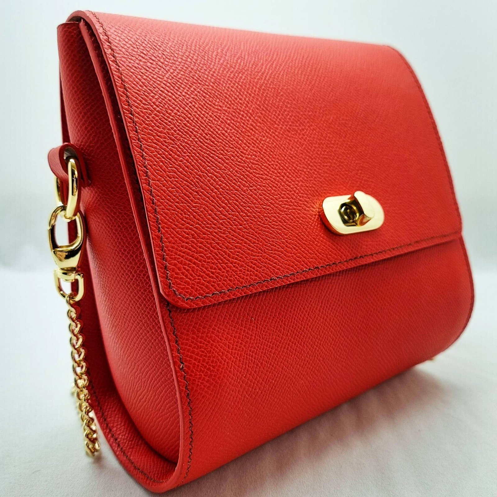 A rouge colored epsom leather purse made by Pila Luxuria in Alberta, Canada displayed from an angle.