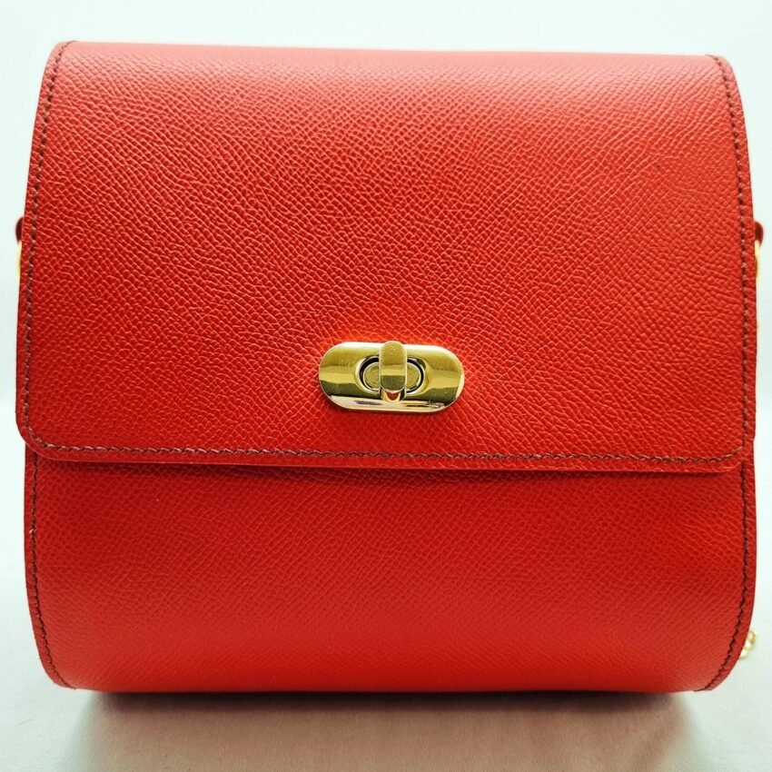 A rouge colored epsom leather purse made by Pila Luxuria in Alberta, Canada displayed from the front.