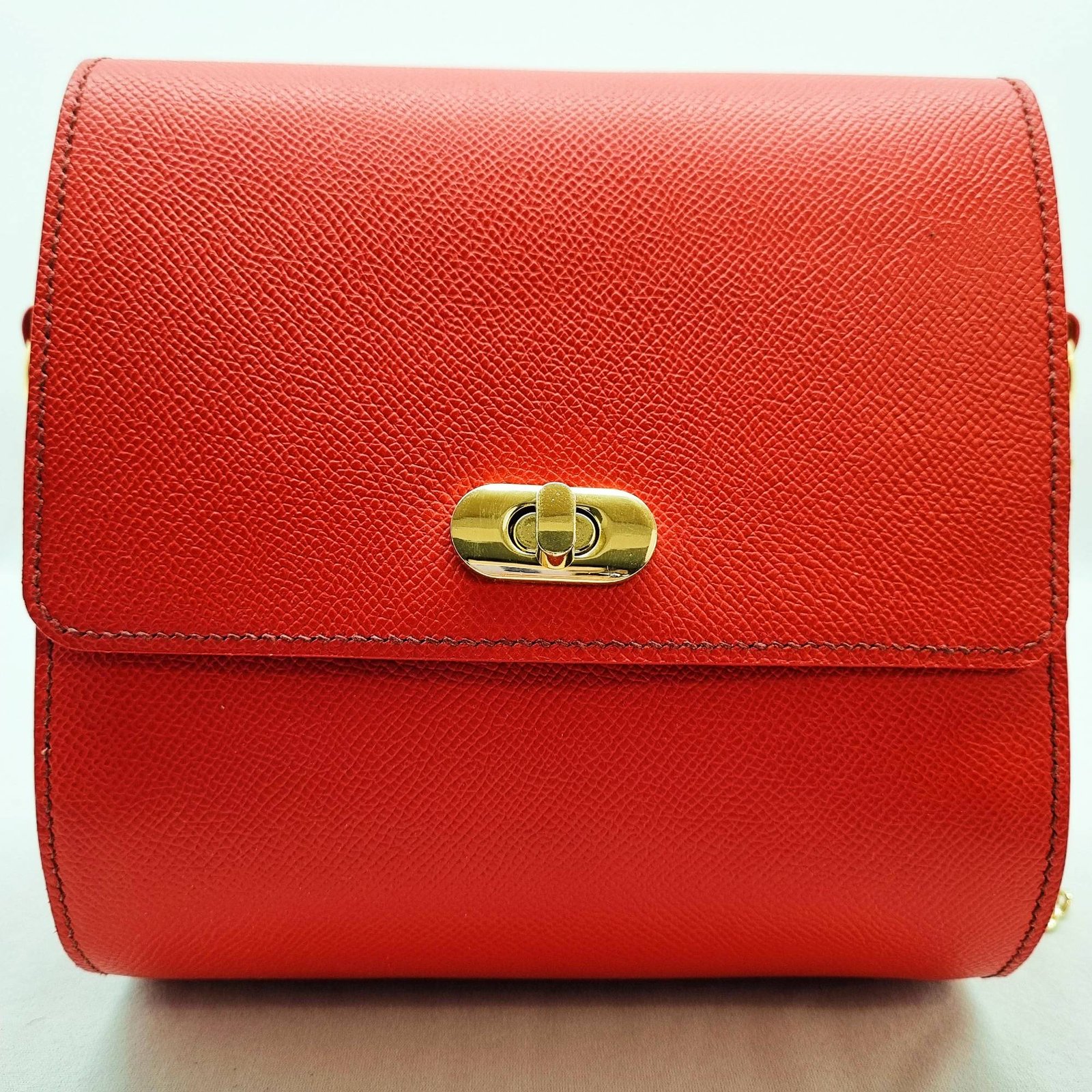 A rouge colored epsom leather purse made by Pila Luxuria in Alberta, Canada displayed from the front.