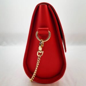 A rouge colored epsom leather purse made by Pila Luxuria in Alberta, Canada displayed from the side.
