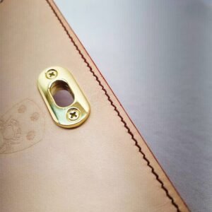 A rouge colored epsom leather purse made by Pila Luxuria in Alberta, Canada showing detailed stitching.