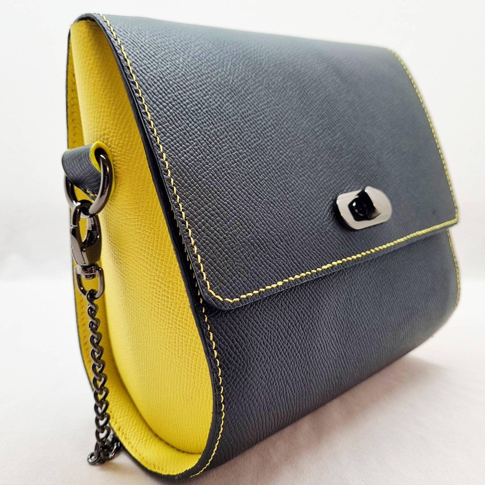 A black and yellow epsom leather purse made by Pila Luxuria in Alberta, Canada displayed from an angle.