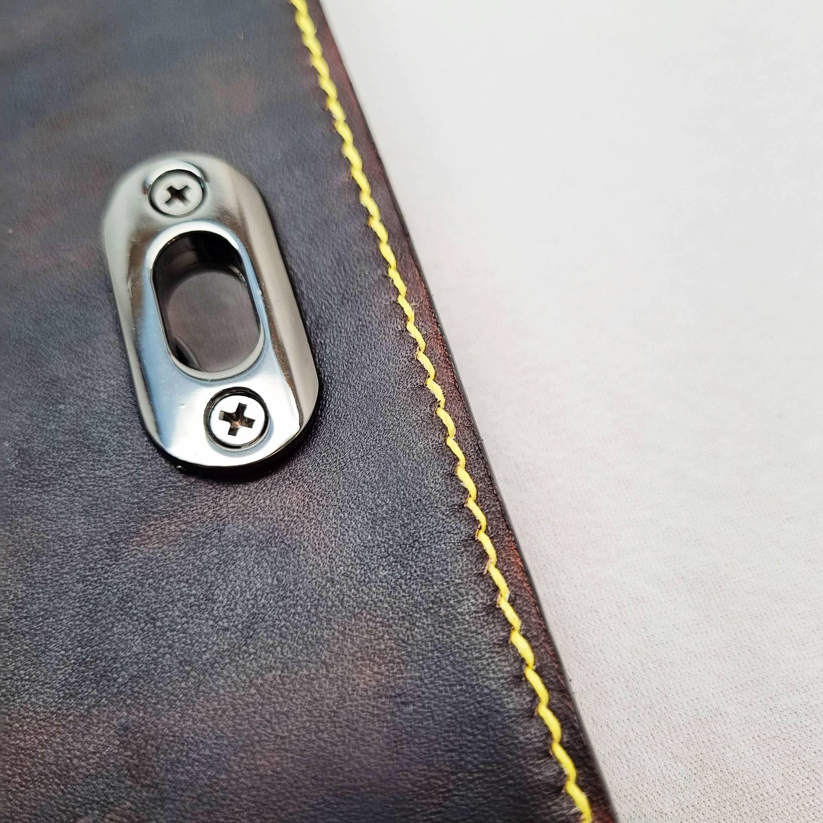 A black and yellow epsom leather purse made by Pila Luxuria in Alberta, Canada showing detailed stitching.