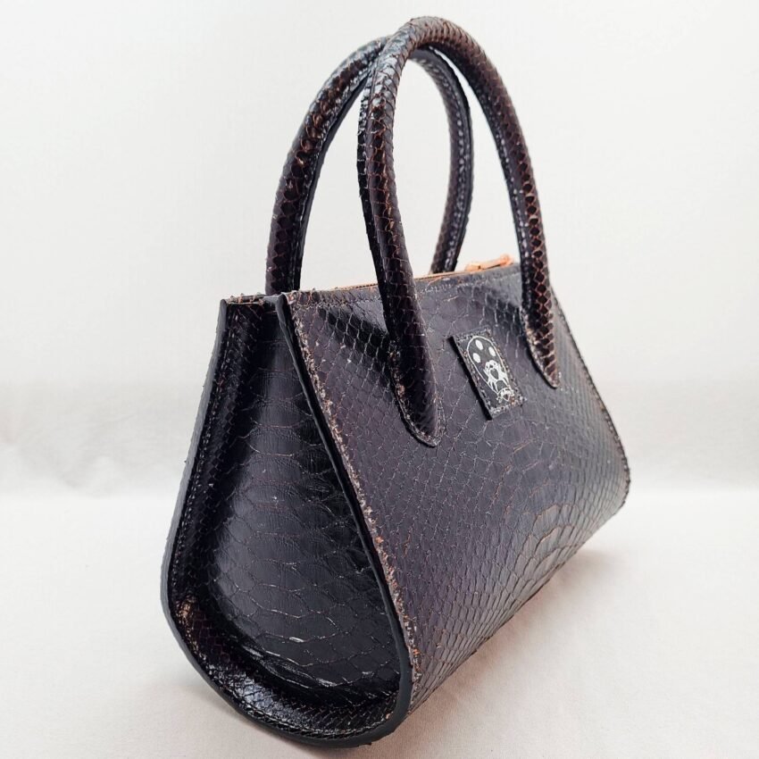 An exotic black python leather handbag made by Pila Luxuria in Alberta, Canada shown from a front angle.