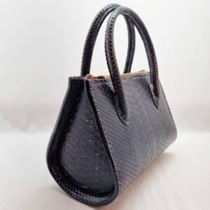 An exotic black python leather handbag made by Pila Luxuria in Alberta, Canada shown from an angle.