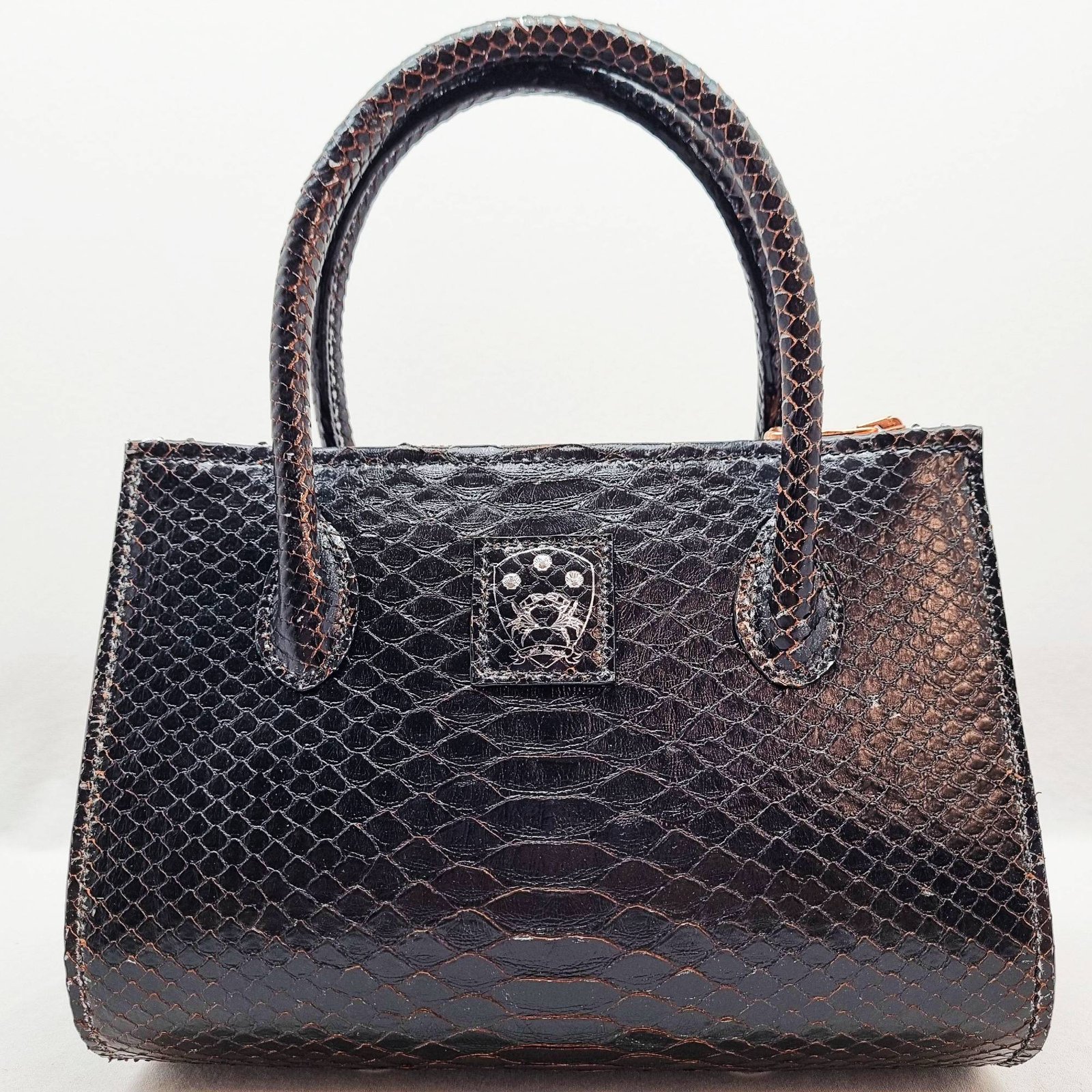An exotic black python leather handbag made by Pila Luxuria in Alberta, Canada shown from the front.
