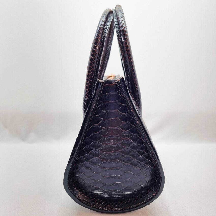 An exotic black python leather handbag made by Pila Luxuria in Alberta, Canada shown from the side.