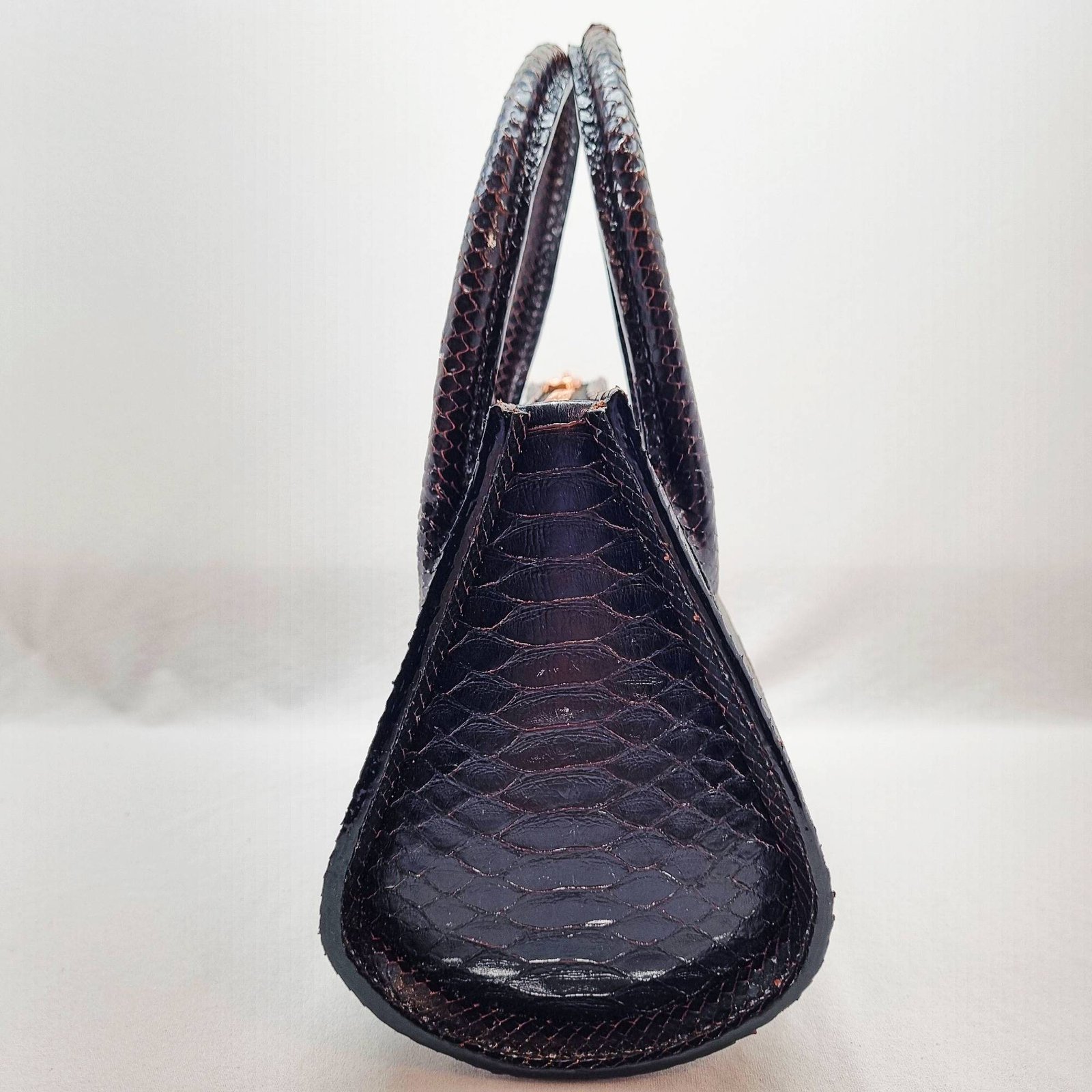 An exotic black python leather handbag made by Pila Luxuria in Alberta, Canada shown from the side.