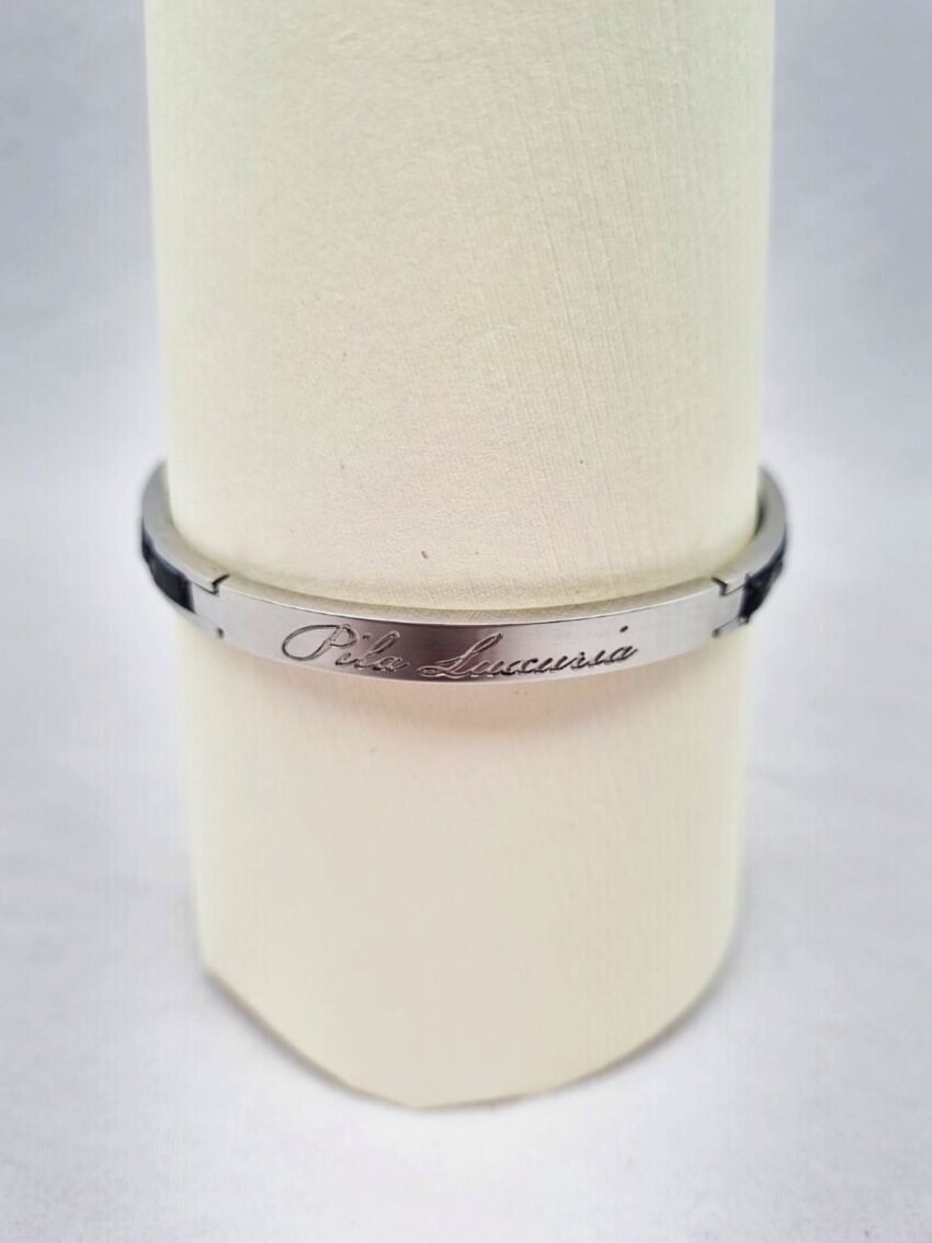 Logo of a luxury black crocodile clasp bracelet, made by Pila Luxuria in Canada.