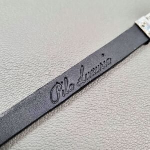 Brand logo of a luxury black crocodile leather bracelet with a magnetic clasp, made by Pila Luxuria in Canada.