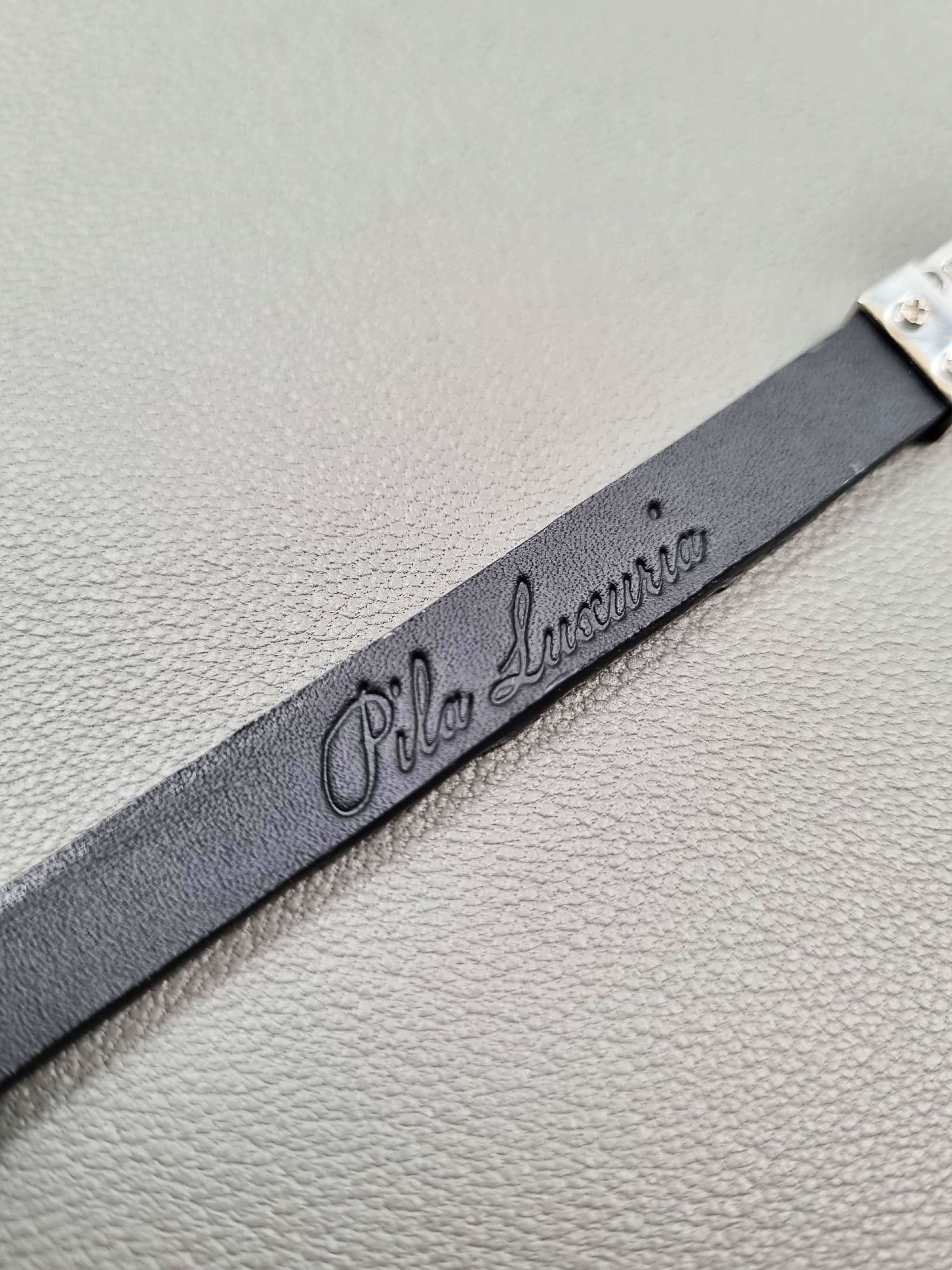 Brand logo of a luxury black crocodile leather bracelet with a magnetic clasp, made by Pila Luxuria in Canada.