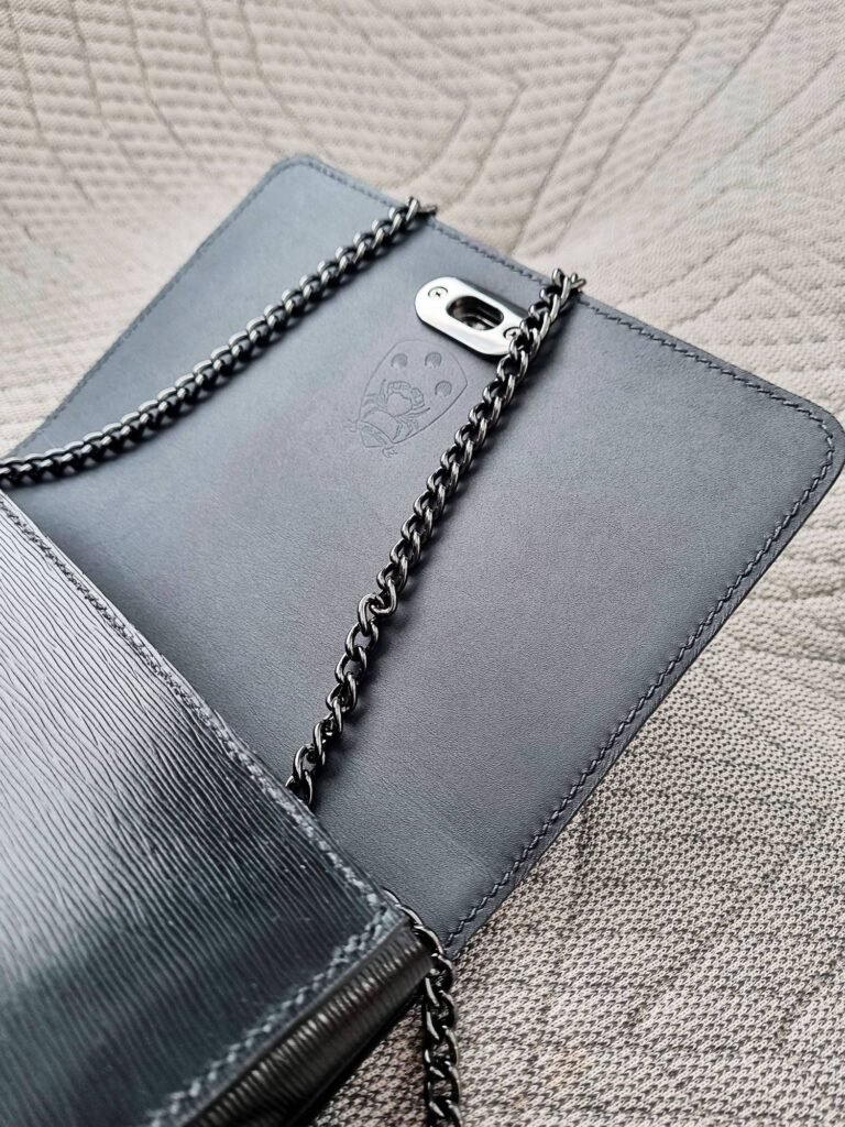 Black Epi leather Chestnut Purse by Pila Luxuria open with chain.