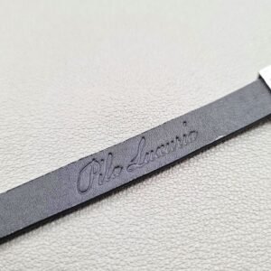 Embossed logo of a luxury black epi leather bracelet with a magnetic clasp, made by Pila Luxuria in Canada.
