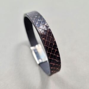 Angled view of a luxury tarnished python leather bracelet with a magnetic clasp, made by Pila Luxuria in Canada.