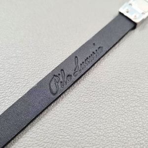 Embossed logo of a luxury tarnished python leather bracelet with a magnetic clasp, made by Pila Luxuria in Canada.