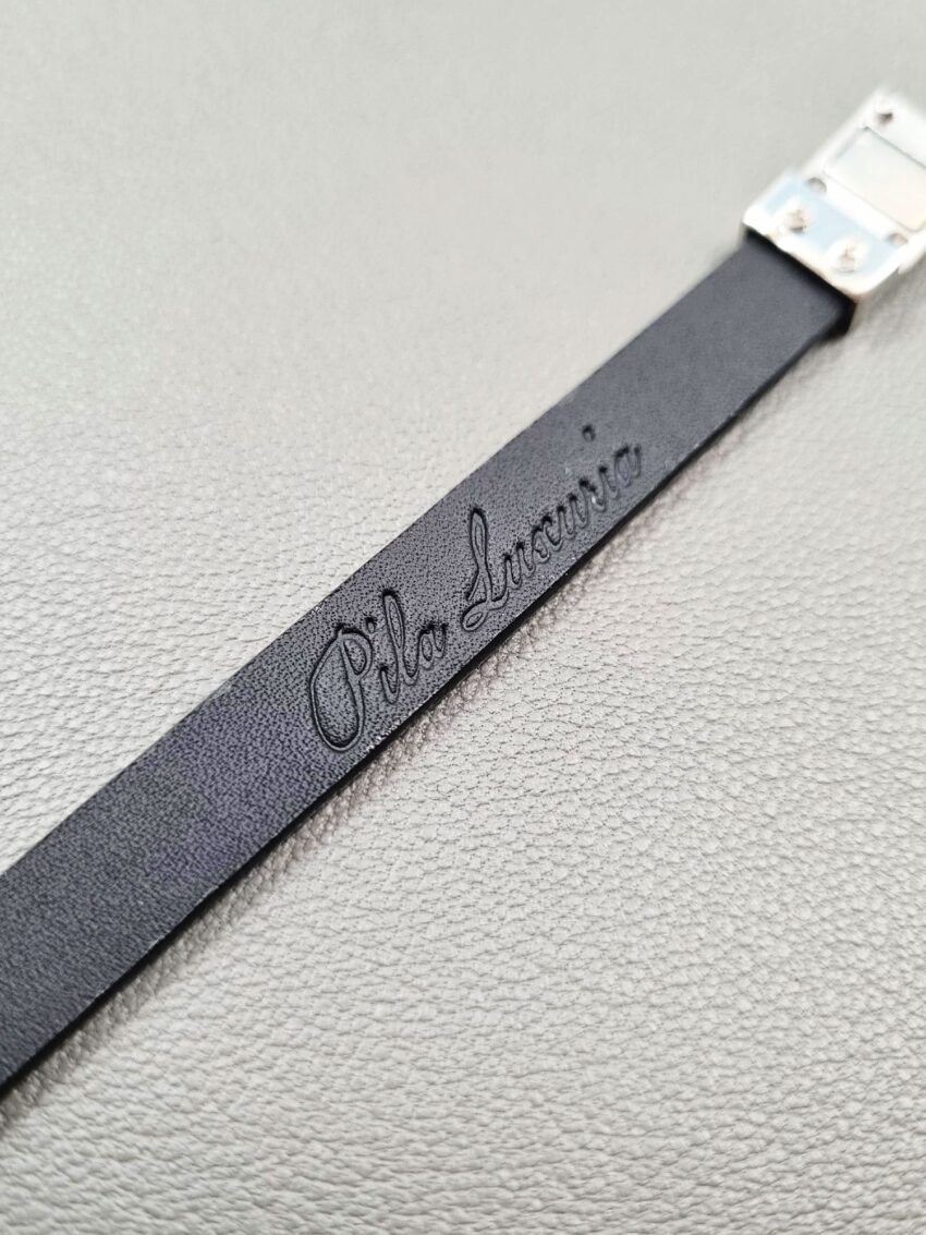 Embossed logo of a luxury tarnished python leather bracelet with a magnetic clasp, made by Pila Luxuria in Canada.