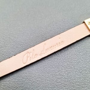 Brand logo of a luxury brown ostrich leather bracelet with a magnetic clasp, made by Pila Luxuria in Canada.