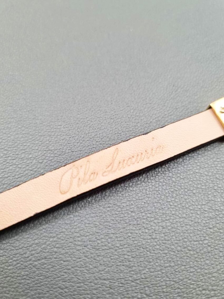 Embossed logo of a luxury brown calfskin leather bracelet with a magnetic clasp, made by Pila Luxuria in Canada.