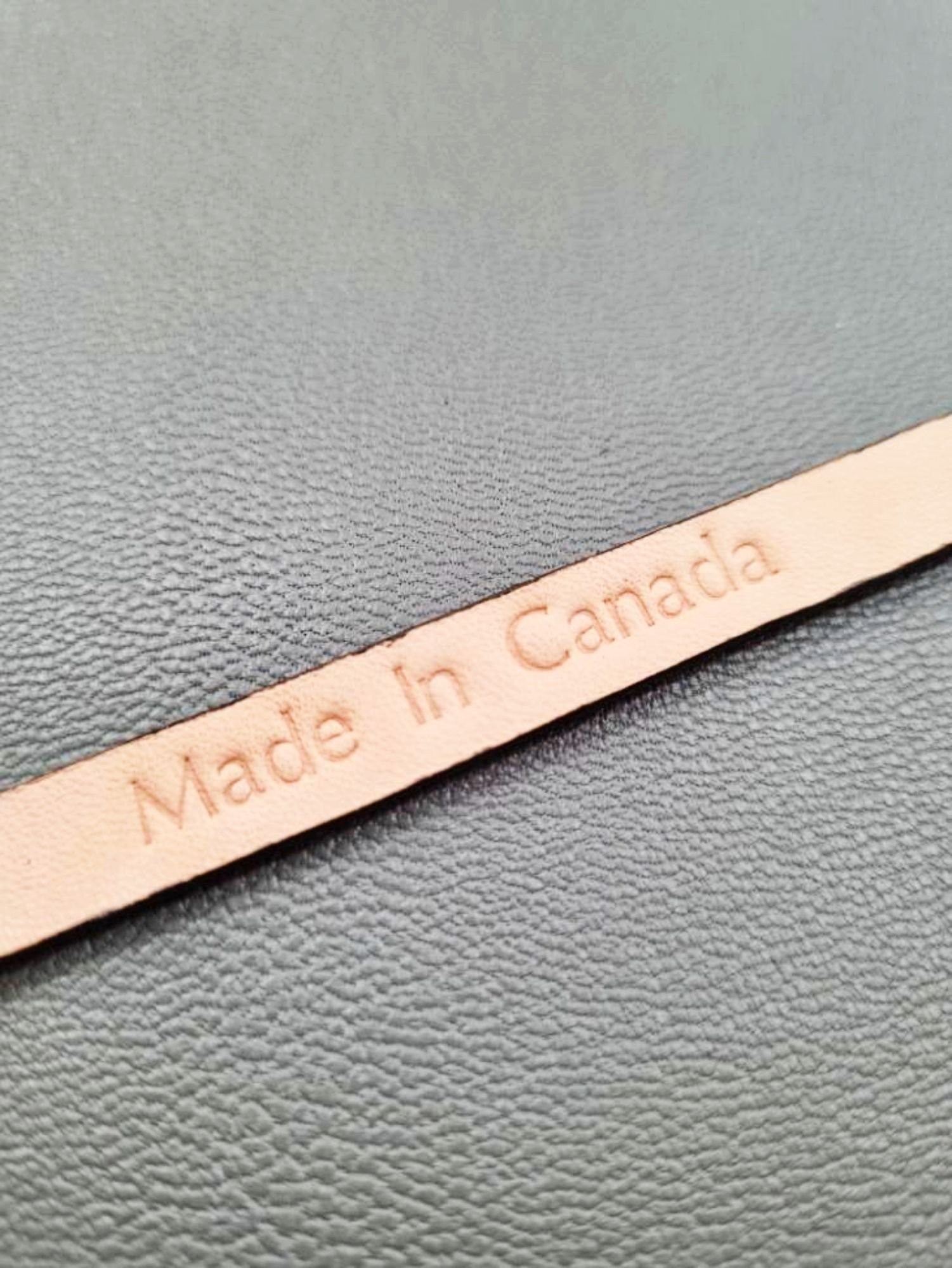 Embossed Made in Canada emblem of a luxury brown calfskin leather bracelet with a magnetic clasp, made by Pila Luxuria in Canada.