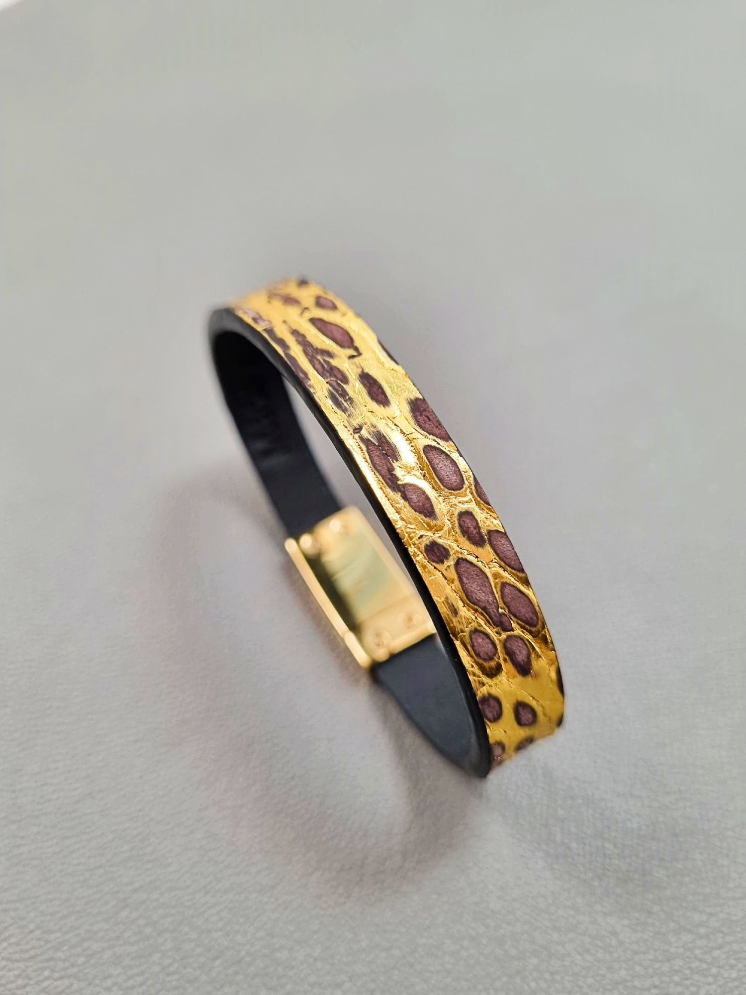 Angled view of a luxury brushed gold crocodile leather bracelet with a magnetic clasp, made by Pila Luxuria in Canada.