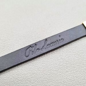Embossed logo of a luxury brushed gold crocodile leather bracelet with a magnetic clasp, made by Pila Luxuria in Canada.