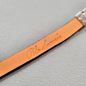 Embossed logo of a luxury cobalt crocodile leather bracelet with a magnetic clasp, made by Pila Luxuria in Canada.