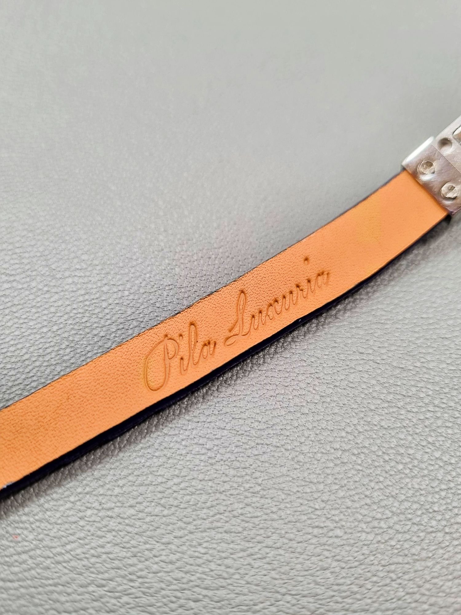 Embossed logo of a luxury cobalt crocodile leather bracelet with a magnetic clasp, made by Pila Luxuria in Canada.