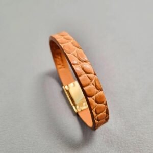 Angled view of a luxury cognac crocodile bracelet with a magnetic clasp, made by Pila Luxuria in Canada.