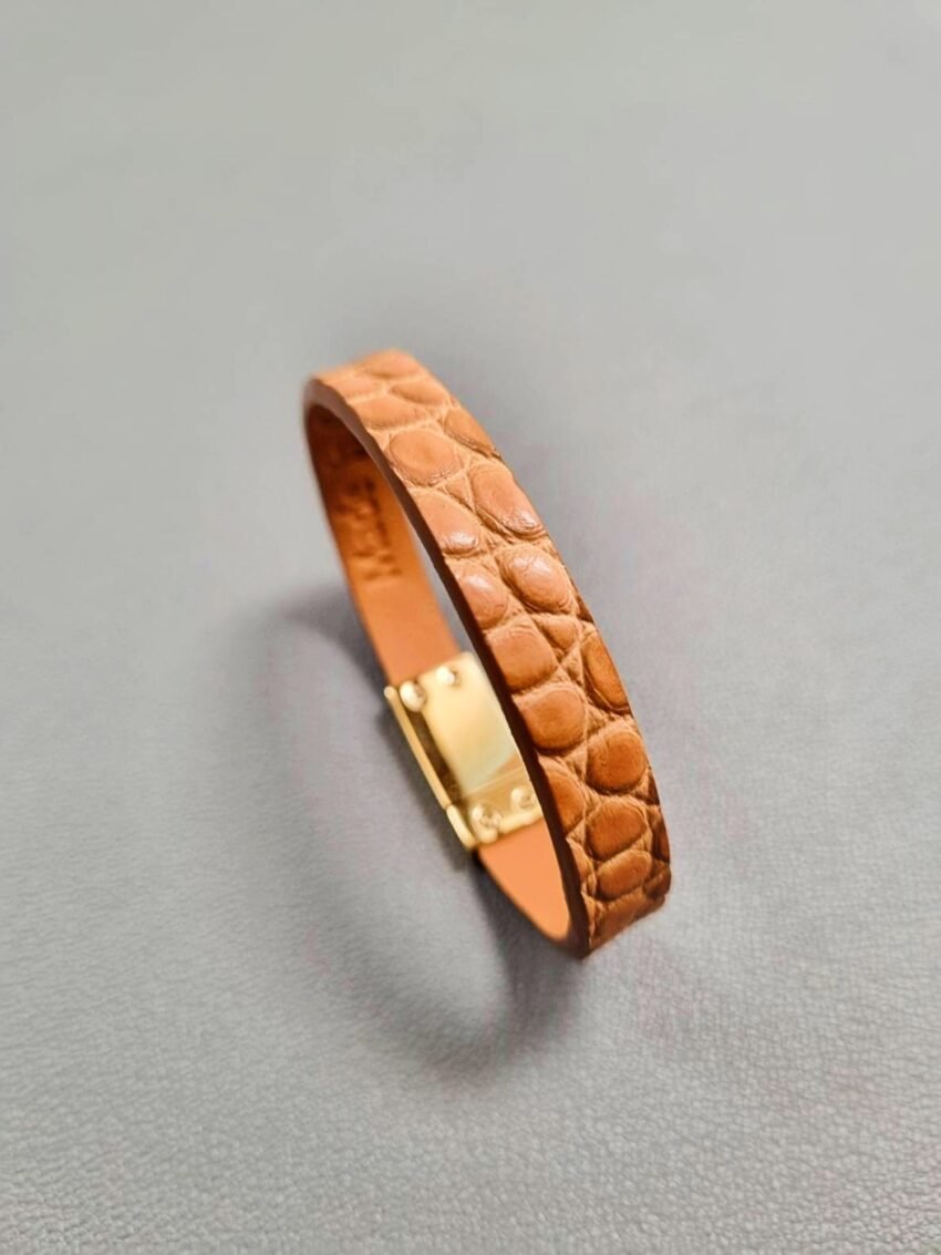 Angled view of a luxury cognac crocodile bracelet with a magnetic clasp, made by Pila Luxuria in Canada.