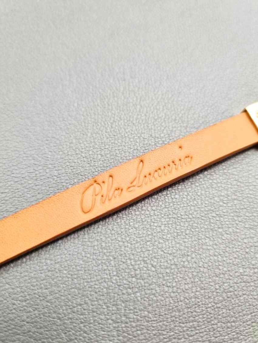 Logo view of a luxury cognac crocodile bracelet with a magnetic clasp, made by Pila Luxuria in Canada.