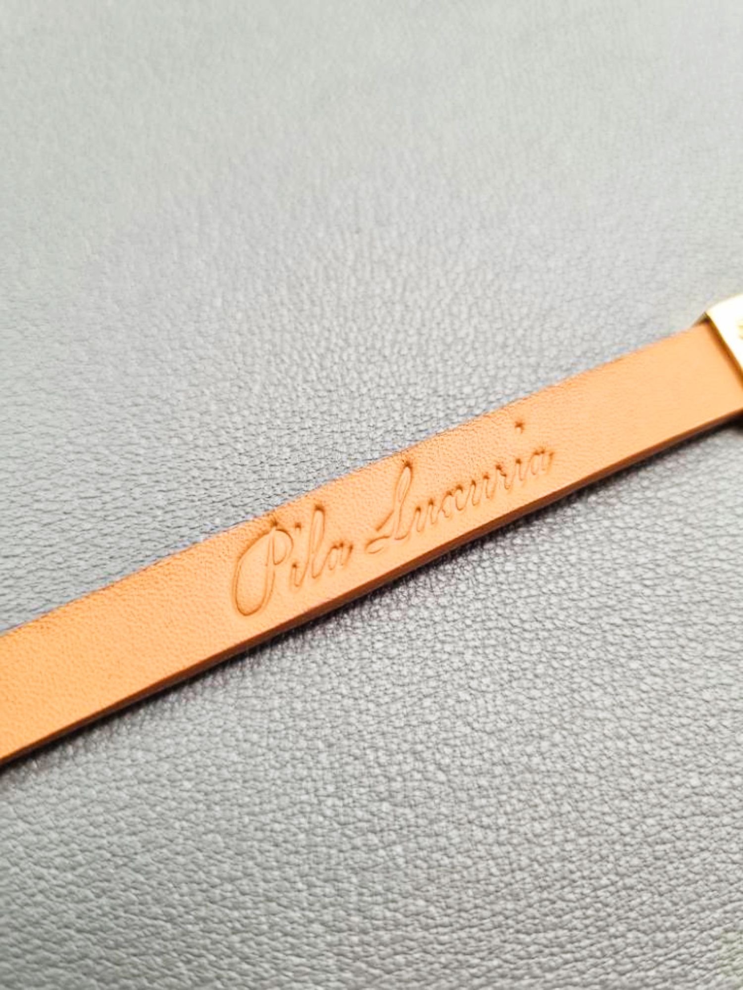 Logo view of a luxury cognac crocodile bracelet with a magnetic clasp, made by Pila Luxuria in Canada.