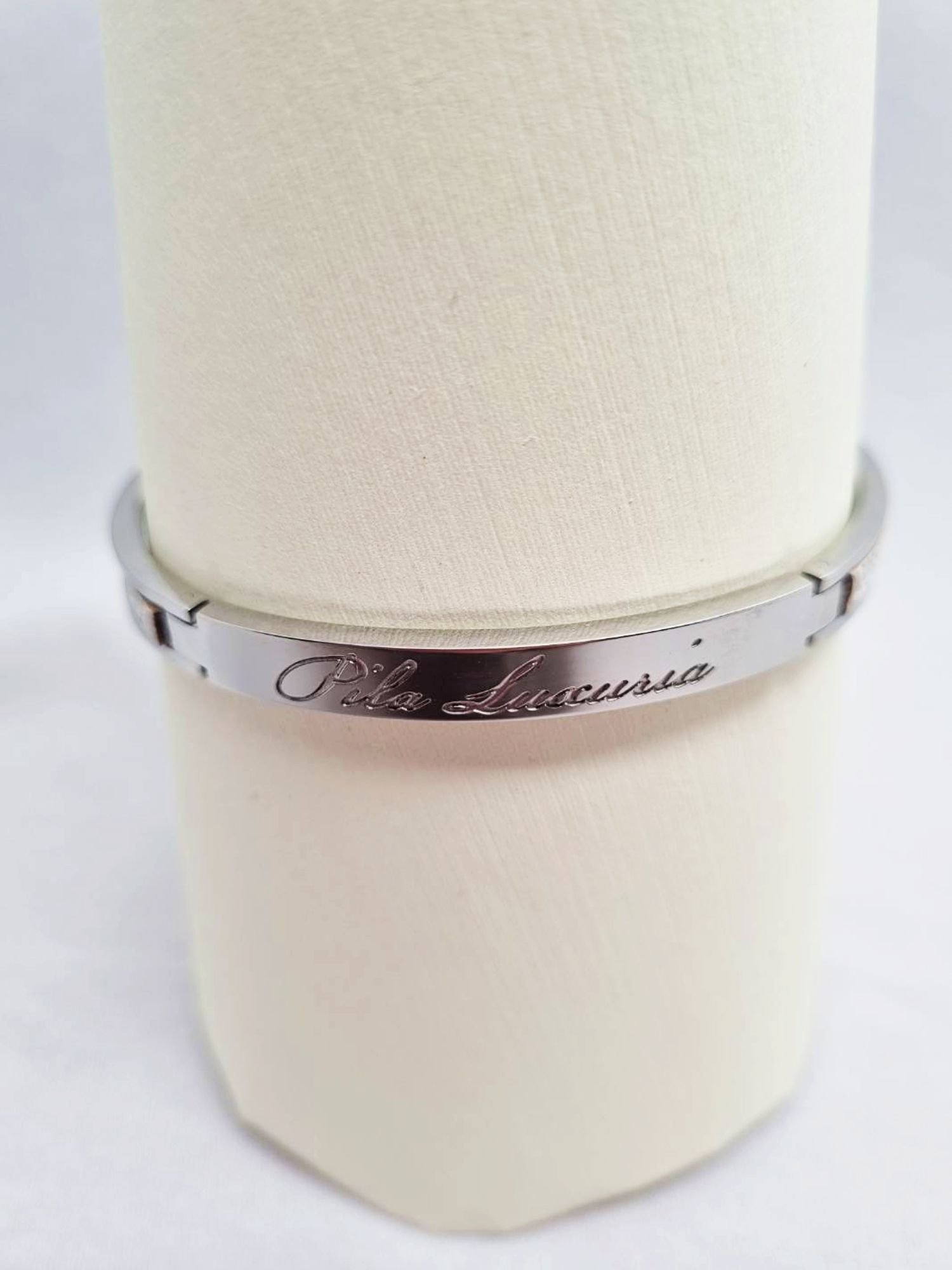 Stainless steel bracelet with cream saffiano leather and Pila Luxuria inscribed logo.