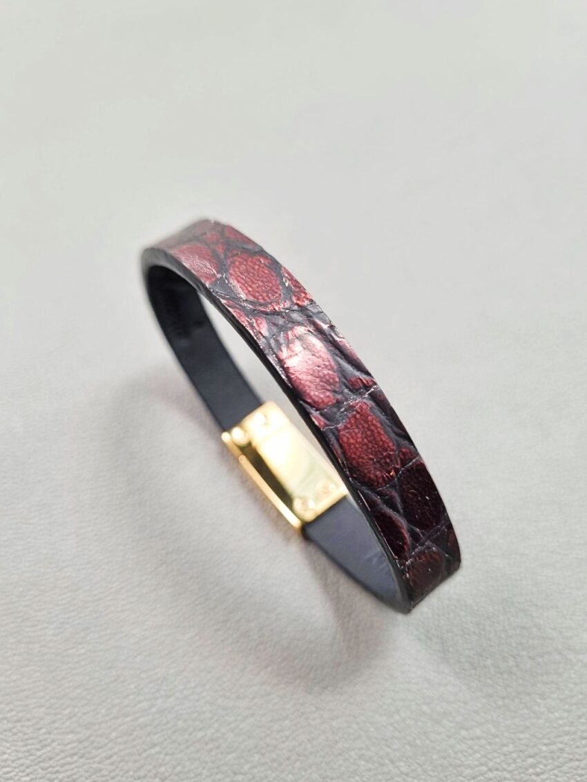 Angled view of a luxury black and red alligator leather bracelet with a magnetic clasp, made by Pila Luxuria in Canada.