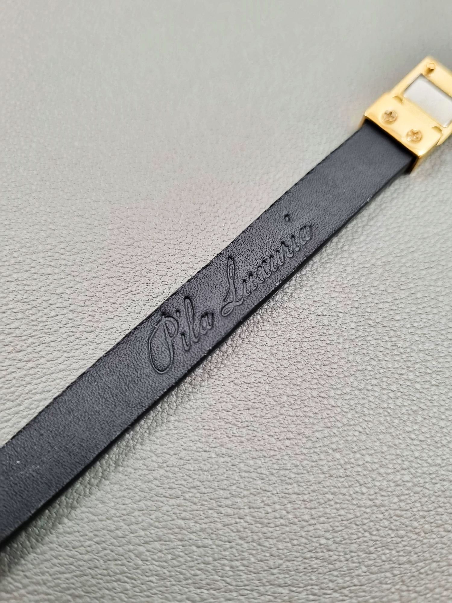 Embossed logo of a luxury black cherry alligator leather bracelet with a magnetic clasp, made by Pila Luxuria in Canada.