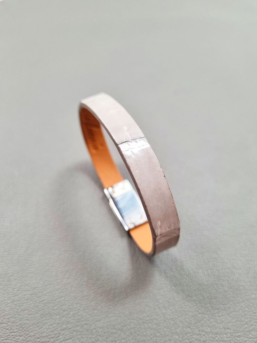 Angled view of a luxury grey crocodile bracelet with a magnetic clasp, made by Pila Luxuria in Canada.