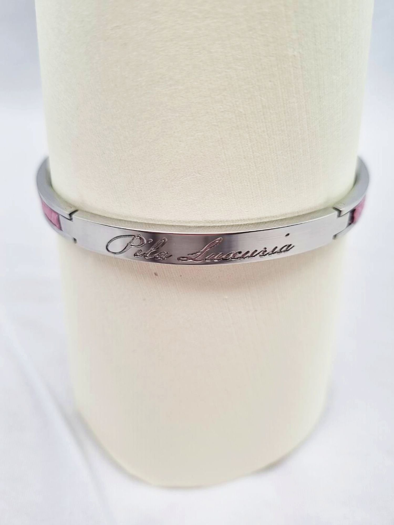 Logo of a luxury pink epsom clasp bracelet, made by Pila Luxuria in Canada.