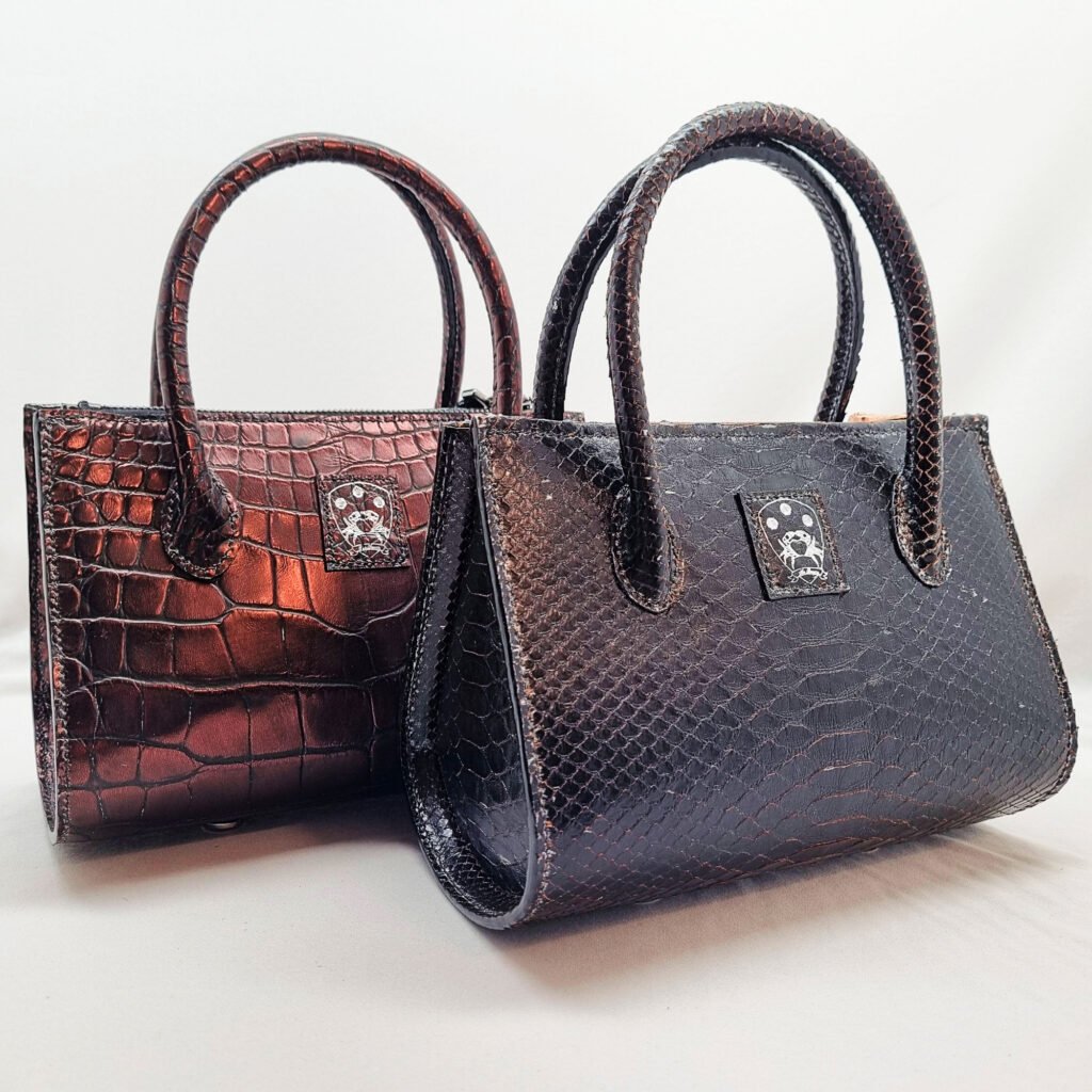 A pair of alligator and python leather tulip handbags made by Pila Luxuria in Canada in a staggered position.