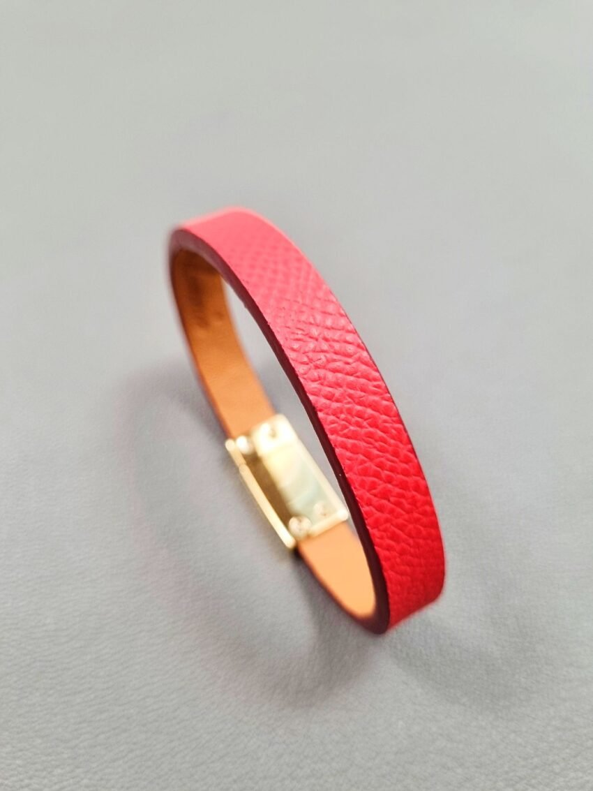 Angled view of a luxury red epsom leather bracelet with a magnetic clasp, made by Pila Luxuria in Canada.
