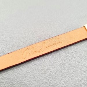 Embossed logo of a luxury red epsom leather bracelet with a magnetic clasp, made by Pila Luxuria in Canada.