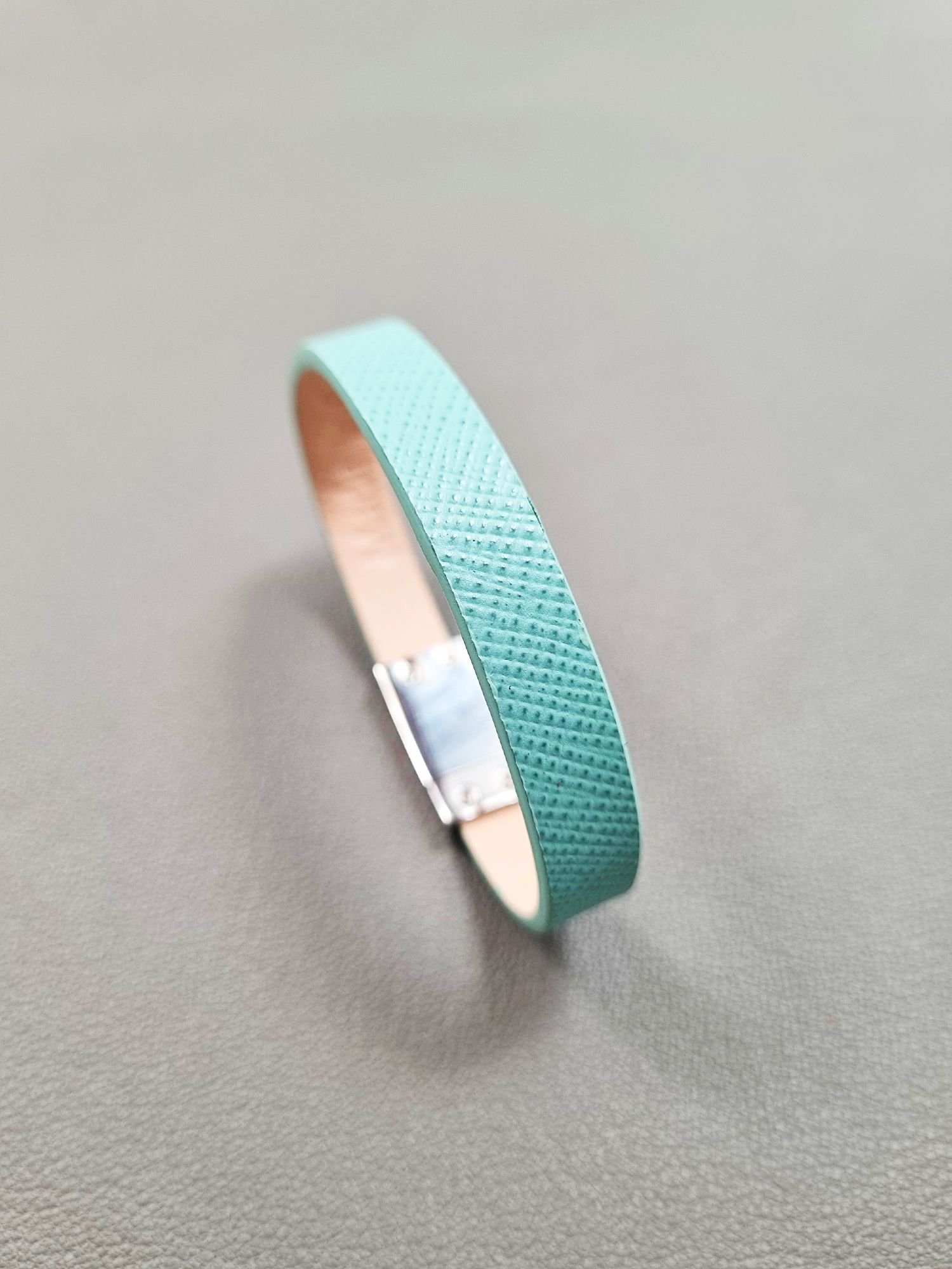Angled view of a luxury tiffany saffiano leather bracelet with a magnetic clasp, made by Pila Luxuria in Canada.