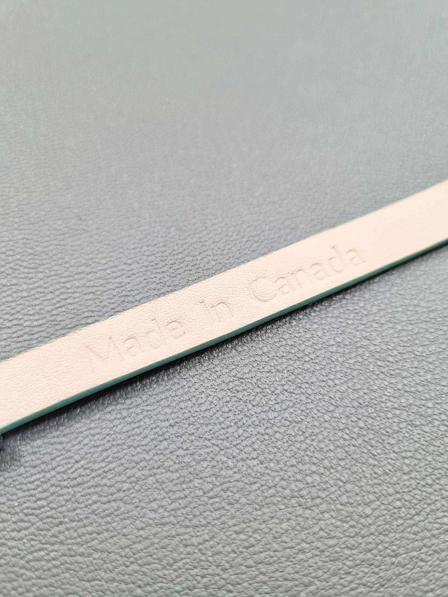 Embossed logo of a luxury tiffany saffiano leather bracelet with a magnetic clasp, made by Pila Luxuria in Canada.